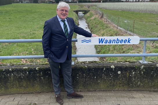 Gedeputeerde Lambrechts bij naambord Waanbeek
